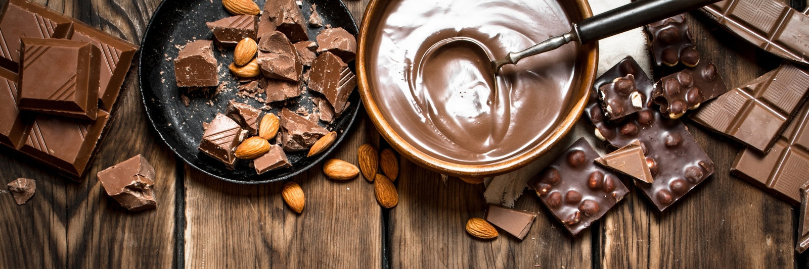 Dark and milk chocolates spread out on a table and melted down using a process called chocolate tempering