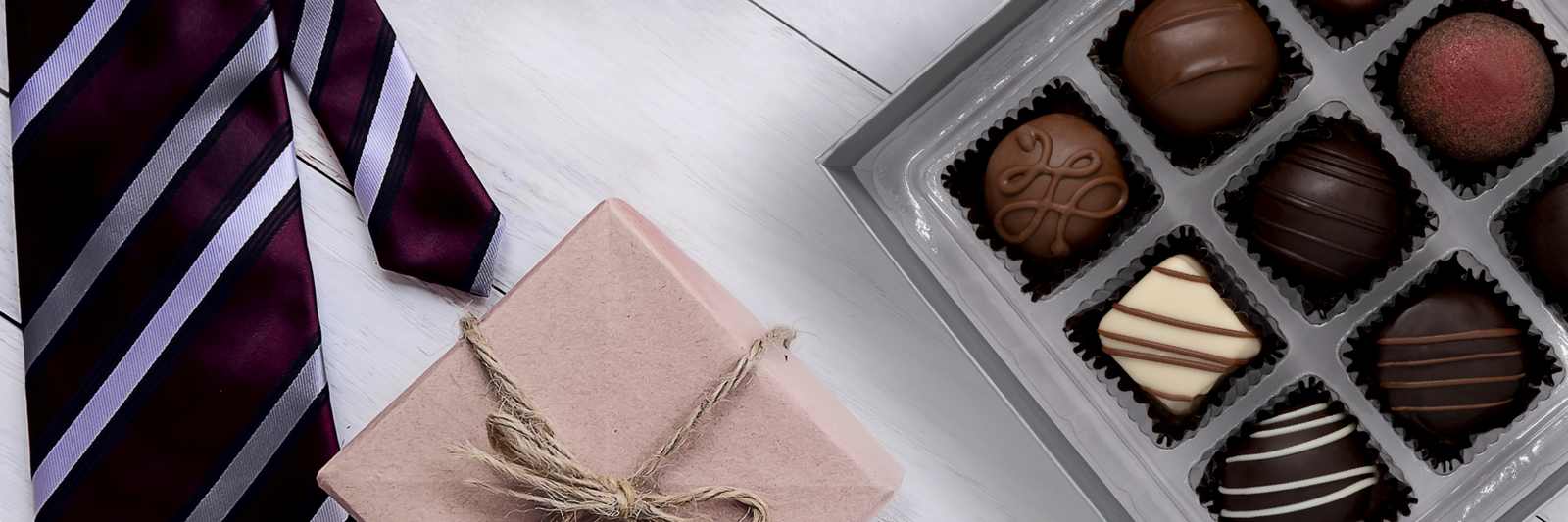 Dilettante's hand-dipped truffles beside a red tie and Father's Day present