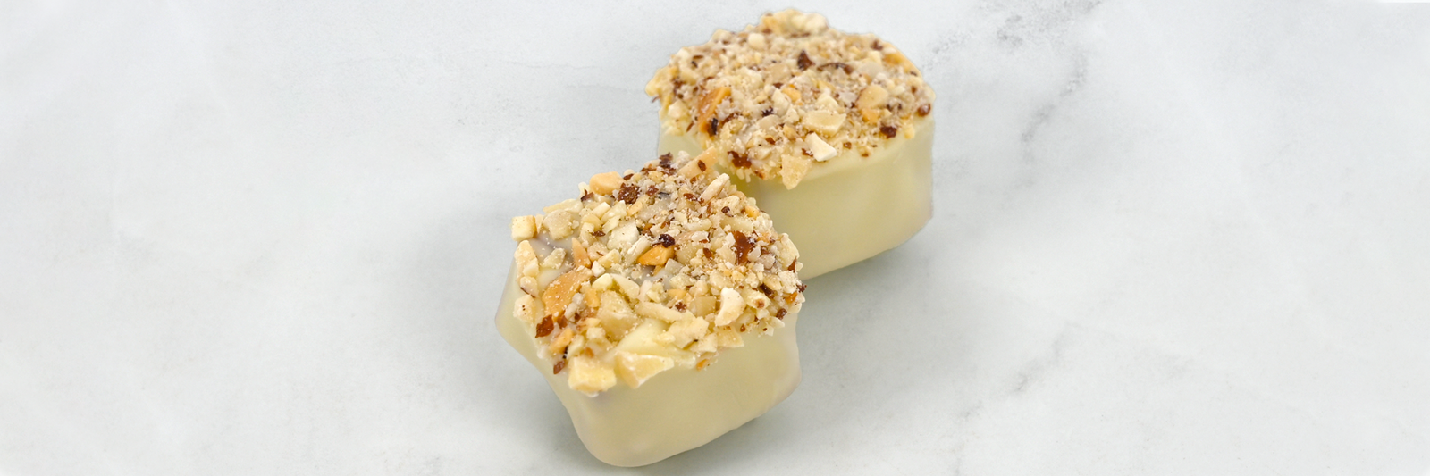 Dilettante Chocolates White Chocolate Rheingold Toffee Behind a Marble Background