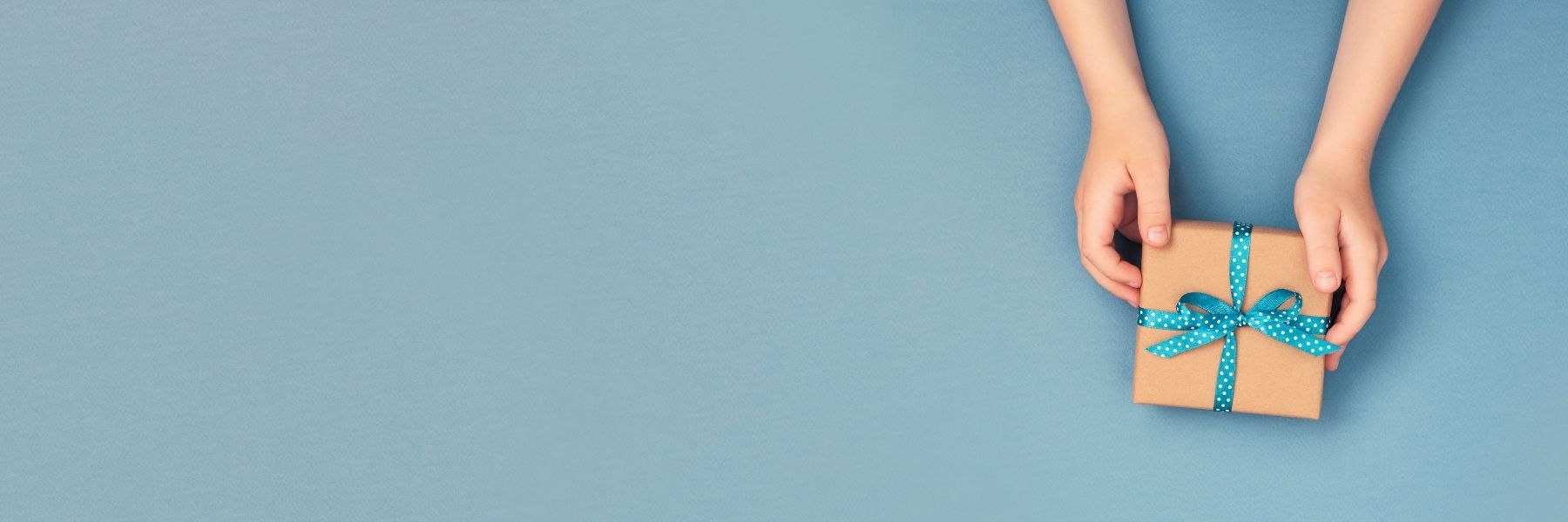 Woman Presenting a Gift Against a Blue Background