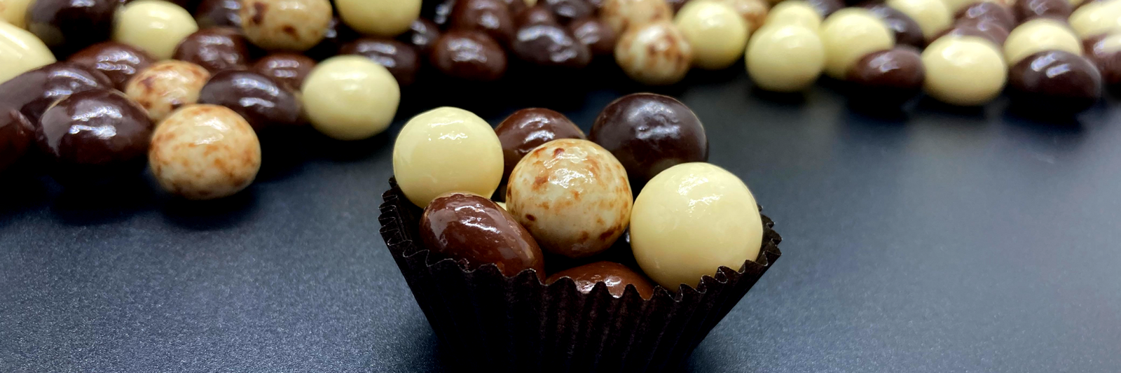 Dilettante Chocolates Milk, Dark, White, and Marbled Espresso Beans in a cup