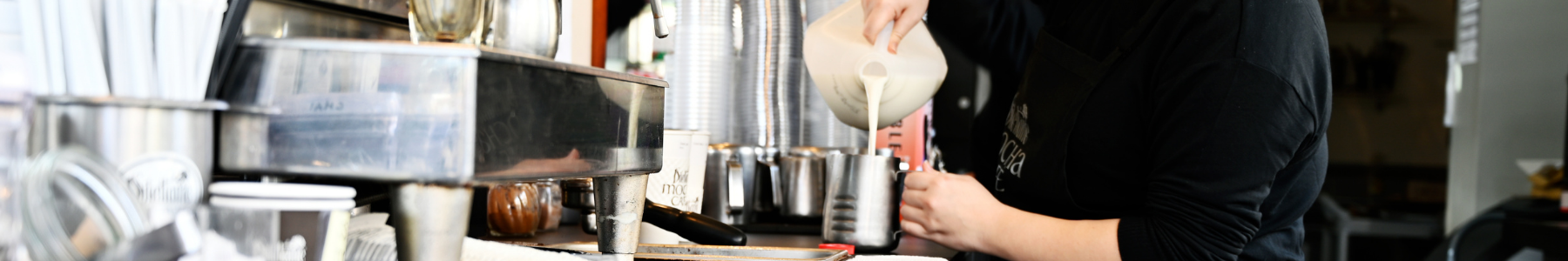 Dilettante Chocolates barista pouring milk into a coffee drink