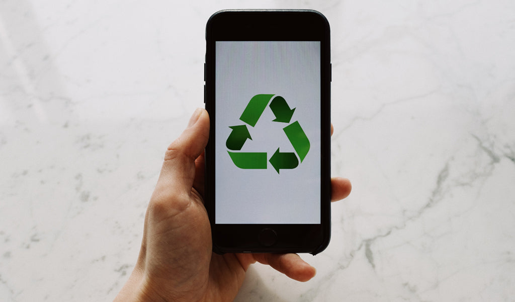 Image of hand holding phone with recycling symbol on the screen